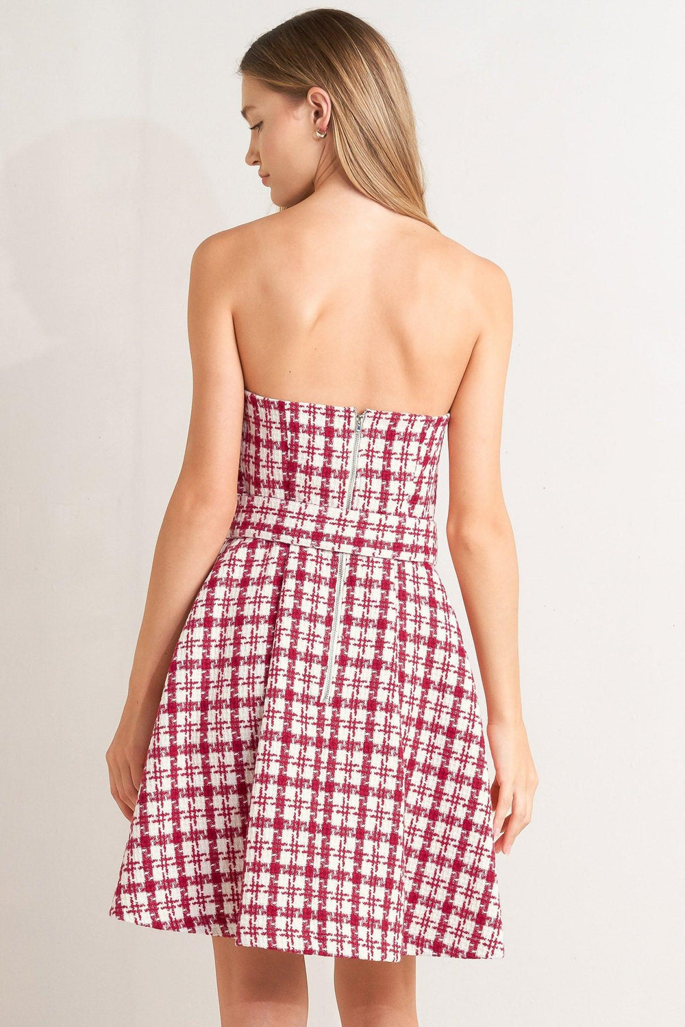 A tweed mini dress featuring strapless, self belt, circle skirt and back zipper closure