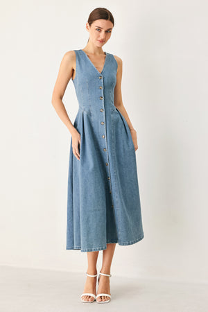 Woman wearing a sleeveless blue denim midi dress with V neckline, button down, and side pleat | FREEMARKET