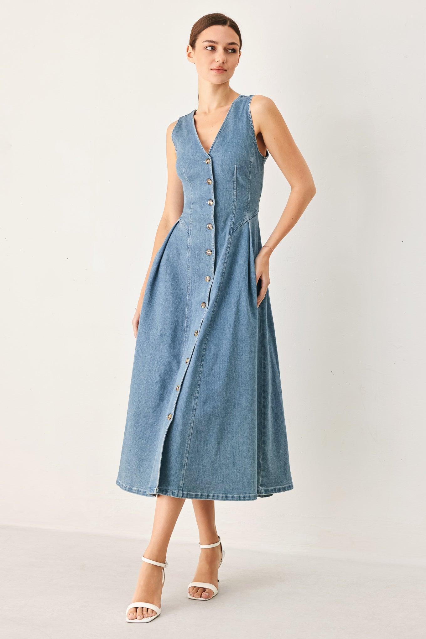 Woman wearing a blue denim dress on a white background