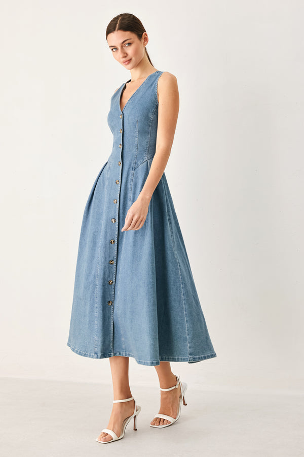 Woman wearing a sleeveless blue denim midi dress with V neckline, button down, and side pleat | FREEMARKET