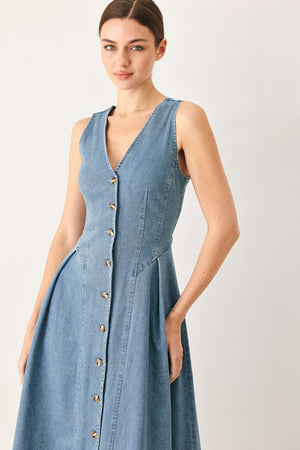 Woman wearing a sleeveless blue denim midi dress with V neckline, button down, and side pleat | FREEMARKET