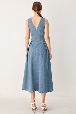 Woman wearing a sleeveless blue denim midi dress with V neckline, button down, and side pleat | FREEMARKET