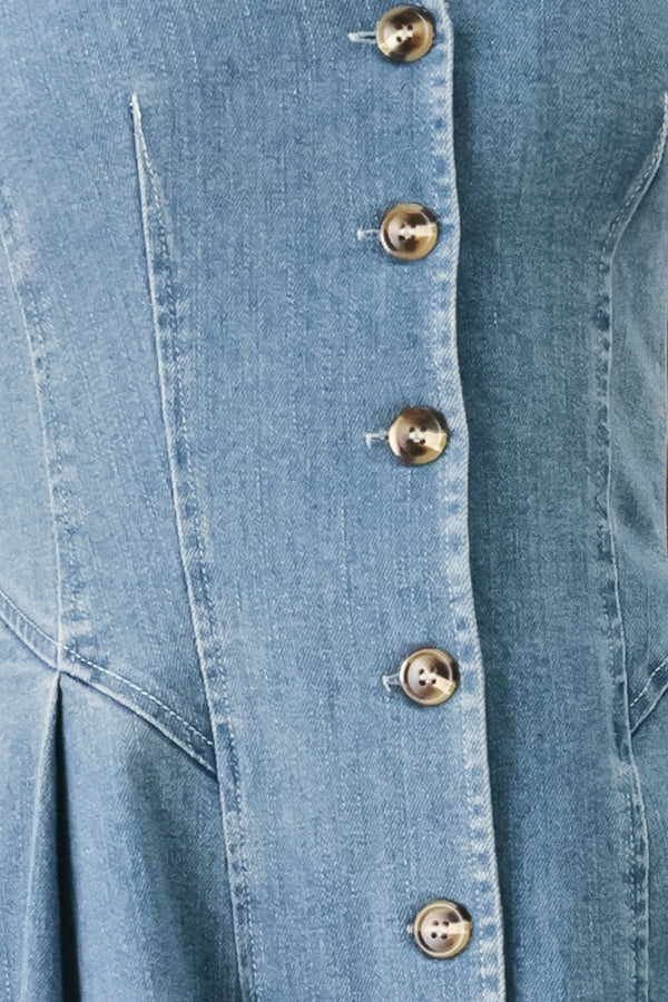 Woman wearing a sleeveless blue denim midi dress with V neckline, button down, and side pleat | FREEMARKET