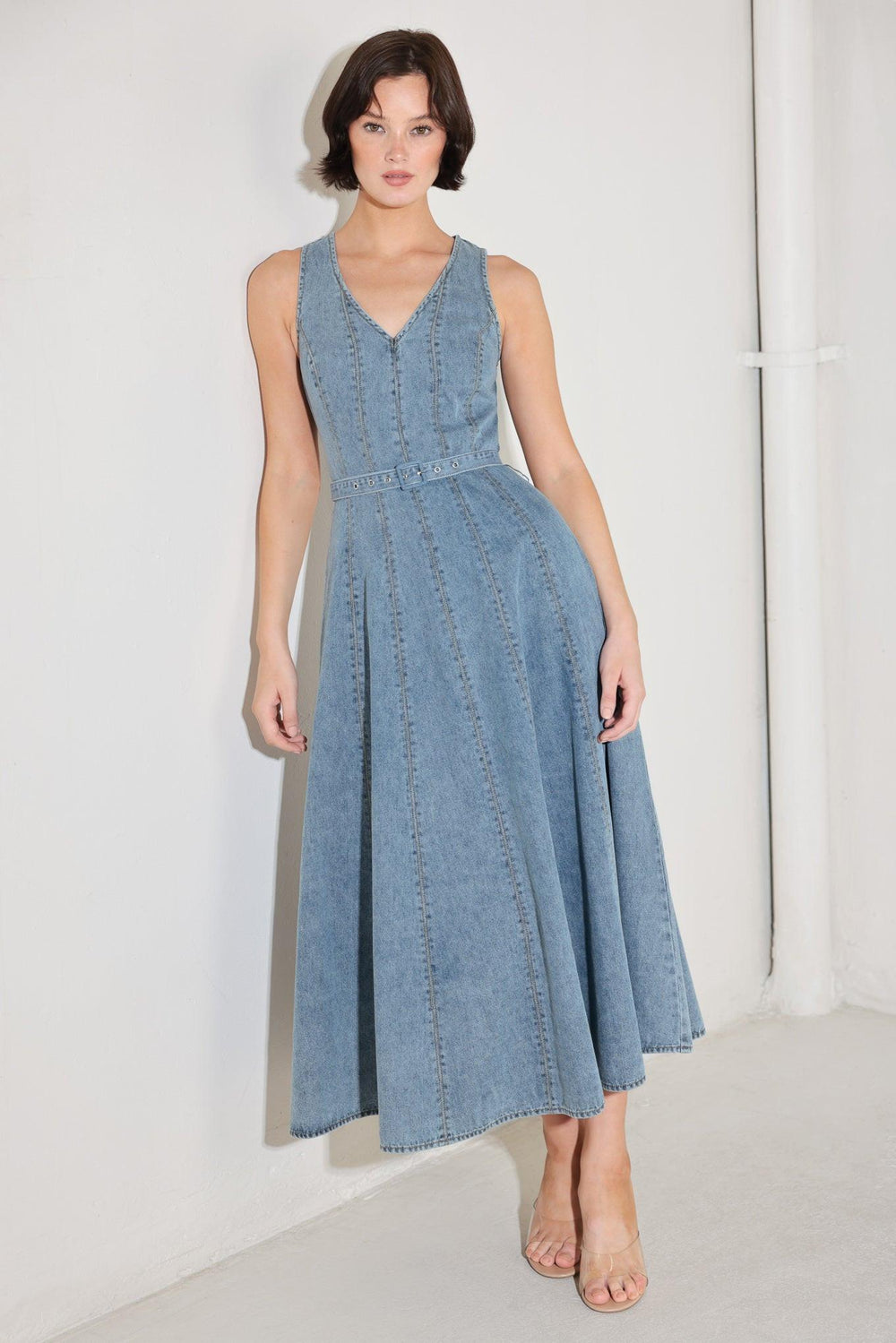 
A washed denim midi dress featuring V neckline, sleeveless, self belt, circle skirt, side pockets and back zipper closure

Details:

Self : 90% Cotton 10% Polyester

Size &amp; Fit

- Model is 5`8" And Wearing Size Small
- Measurements Taken From Size Small
- Approx. Length: 50"