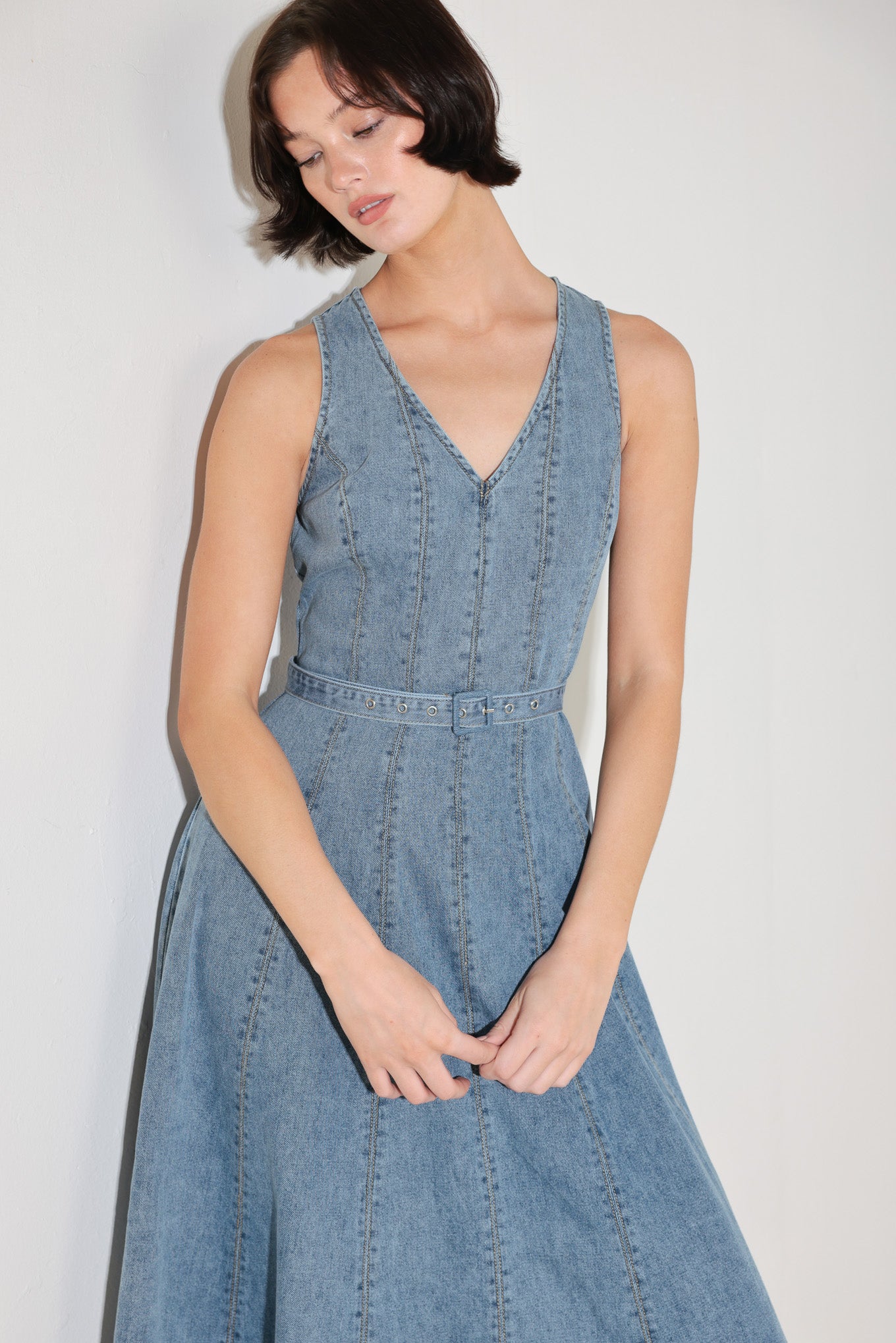 
A washed denim midi dress featuring V neckline, sleeveless, self belt, circle skirt, side pockets and back zipper closure

Details:

Self : 90% Cotton 10% Polyester

Size &amp; Fit

- Model is 5`8" And Wearing Size Small
- Measurements Taken From Size Small
- Approx. Length: 50"