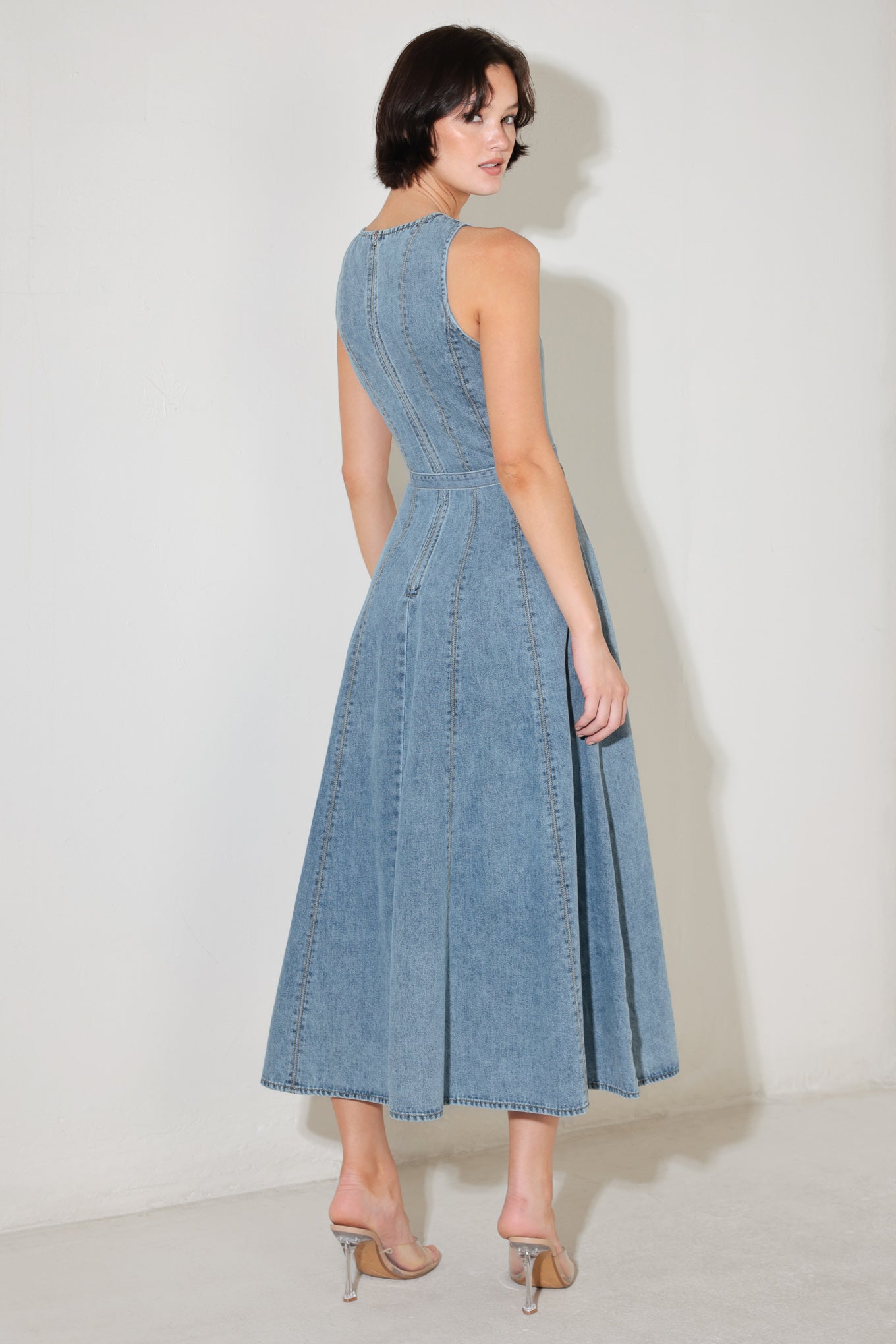 
A washed denim midi dress featuring V neckline, sleeveless, self belt, circle skirt, side pockets and back zipper closure

Details:

Self : 90% Cotton 10% Polyester

Size &amp; Fit

- Model is 5`8" And Wearing Size Small
- Measurements Taken From Size Small
- Approx. Length: 50"