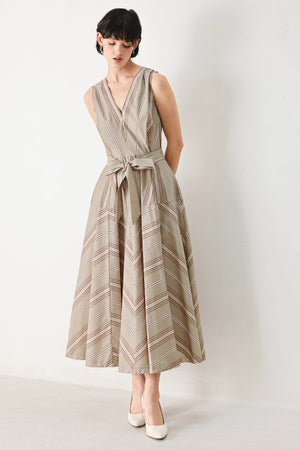 Woman wearing a striped sleeveless woven midi dress featuring V neckline, drop waist, self tie, circle skirt and back zipper closure | FREEMARKET
