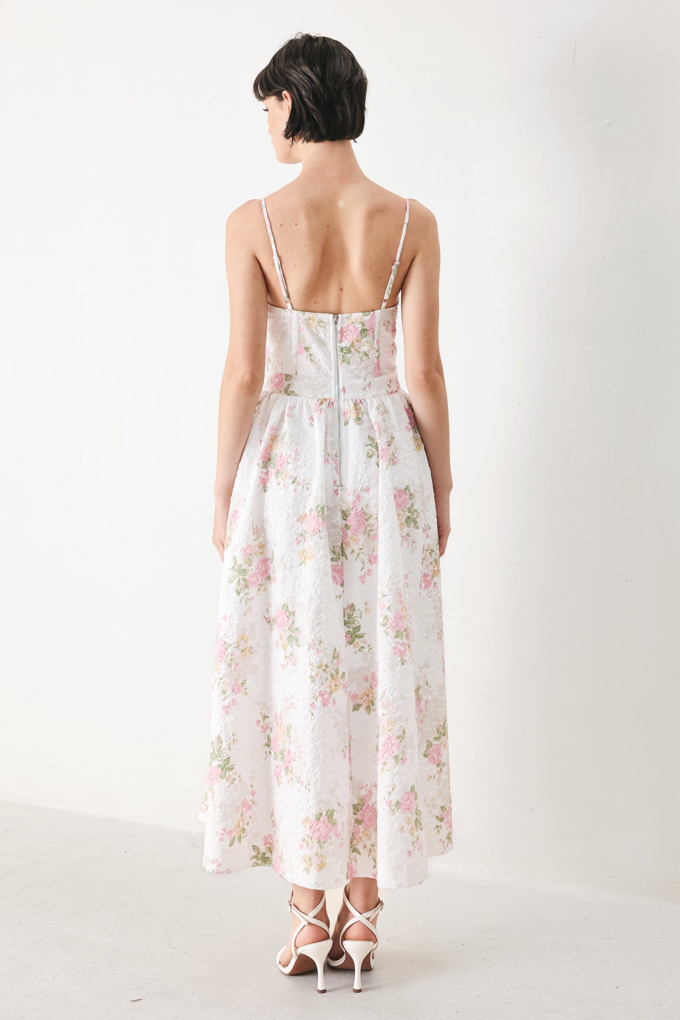 Woman wearing a floral midi dress featuring bustier top, straps, full skirt and back zipper closure | FREEMARKET