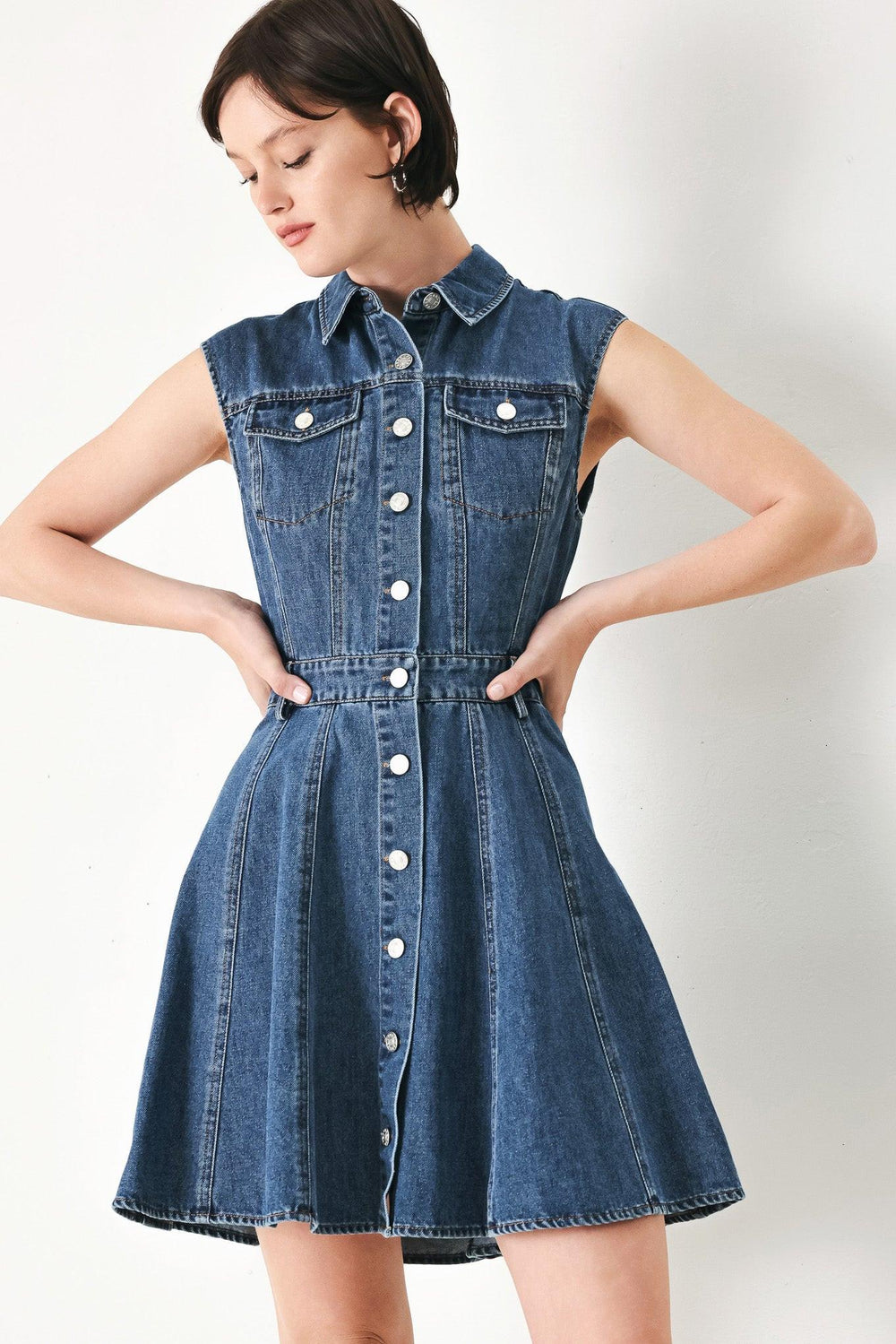 A washed denim mini dress featuring collar, short sleeve, front pockets, front button down and circle skirt