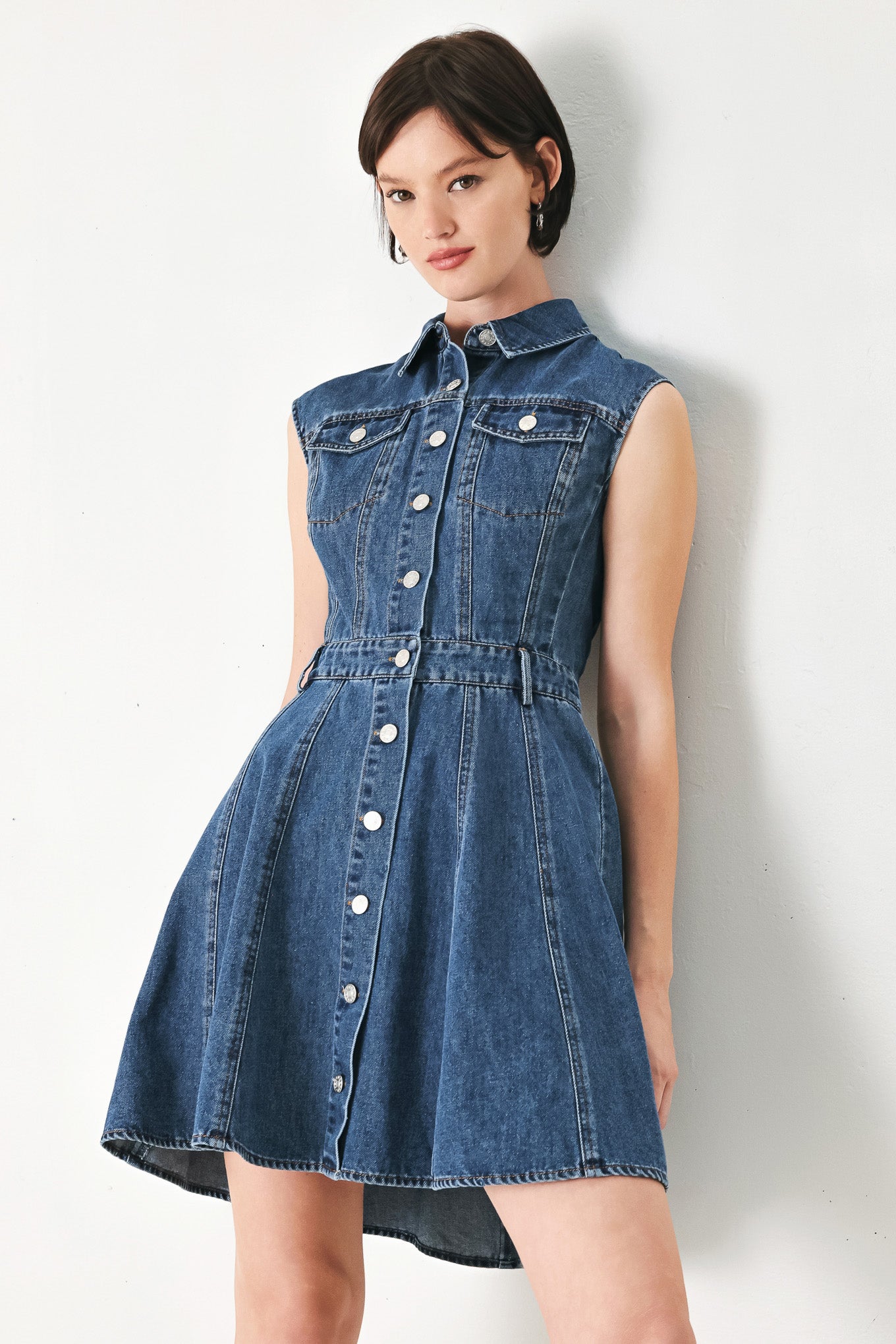 A washed denim mini dress featuring collar, short sleeve, front pockets, front button down and circle skirt