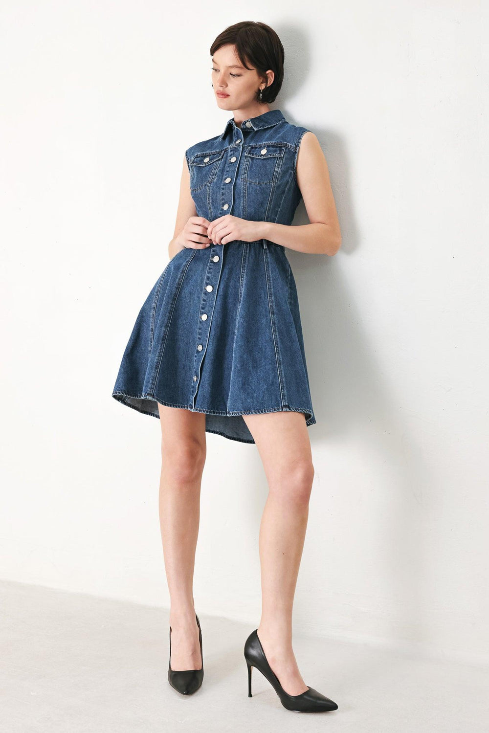 A washed denim mini dress featuring collar, short sleeve, front pockets, front button down and circle skirt