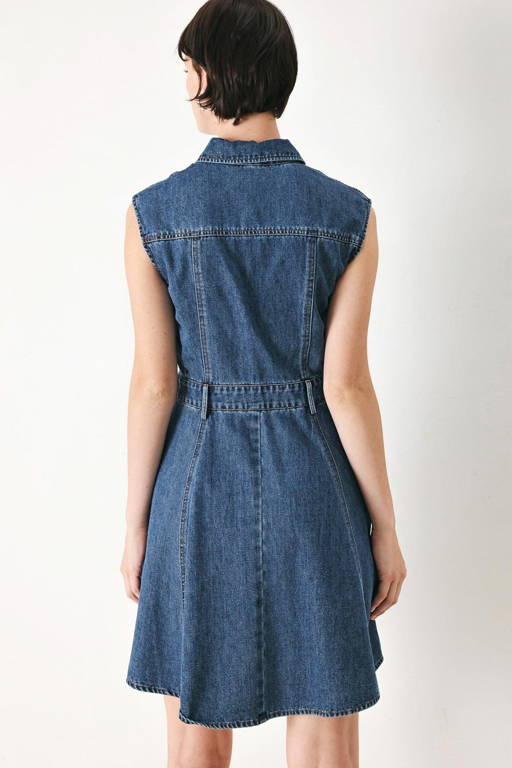 A washed denim mini dress featuring collar, short sleeve, front pockets, front button down and circle skirt