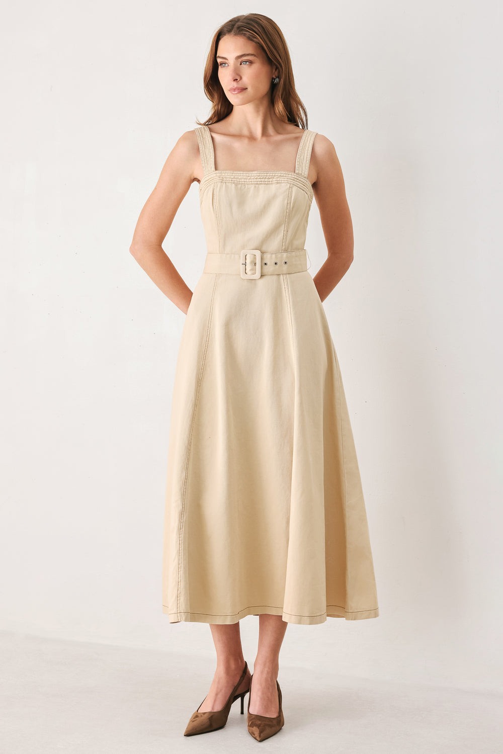 A woman modeling a sleeveless midi dress in a light beige or neutral color, featuring a square neckline, a matching belt at the waist, and a flared skirt | FREEMARKET