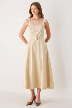 A woman modeling a sleeveless midi dress in a light beige or neutral color, featuring a square neckline, a matching belt at the waist, and a flared skirt | FREEMARKET
