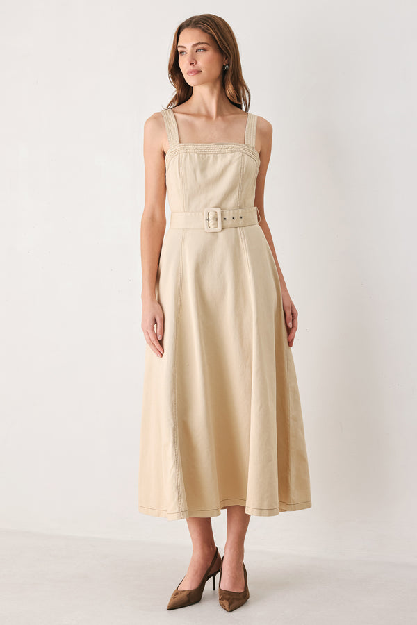 A woman modeling a sleeveless midi dress in a light beige or neutral color, featuring a square neckline, a matching belt at the waist, and a flared skirt | FREEMARKET