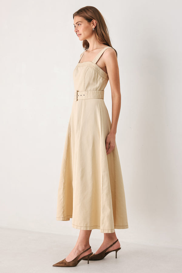 A woman modeling a sleeveless midi dress in a light beige or neutral color, featuring a square neckline, a matching belt at the waist, and a flared skirt | FREEMARKET