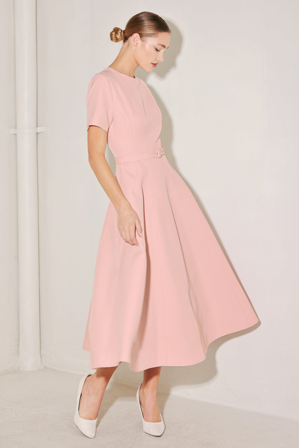 Woman wearing a pink dress against a white background