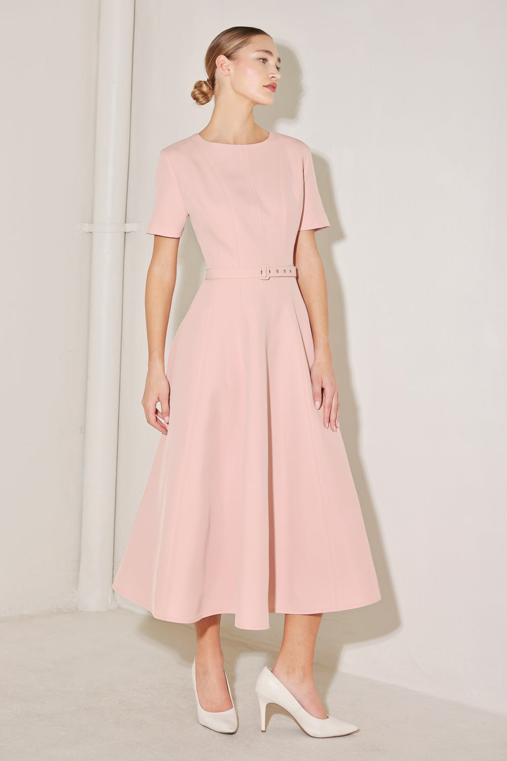 Woman wearing a pink dress against a white background