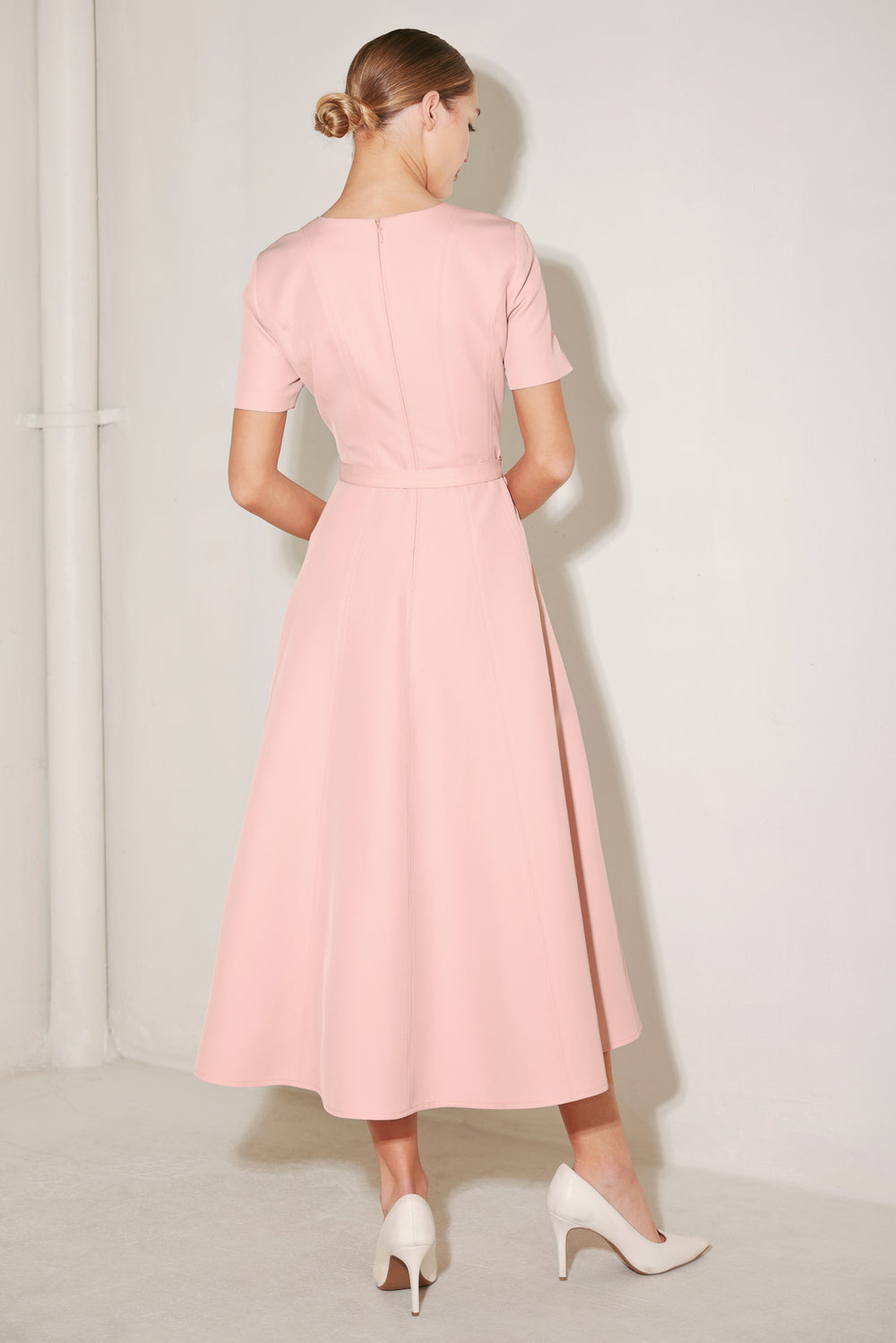 Woman wearing a pink dress against a white background