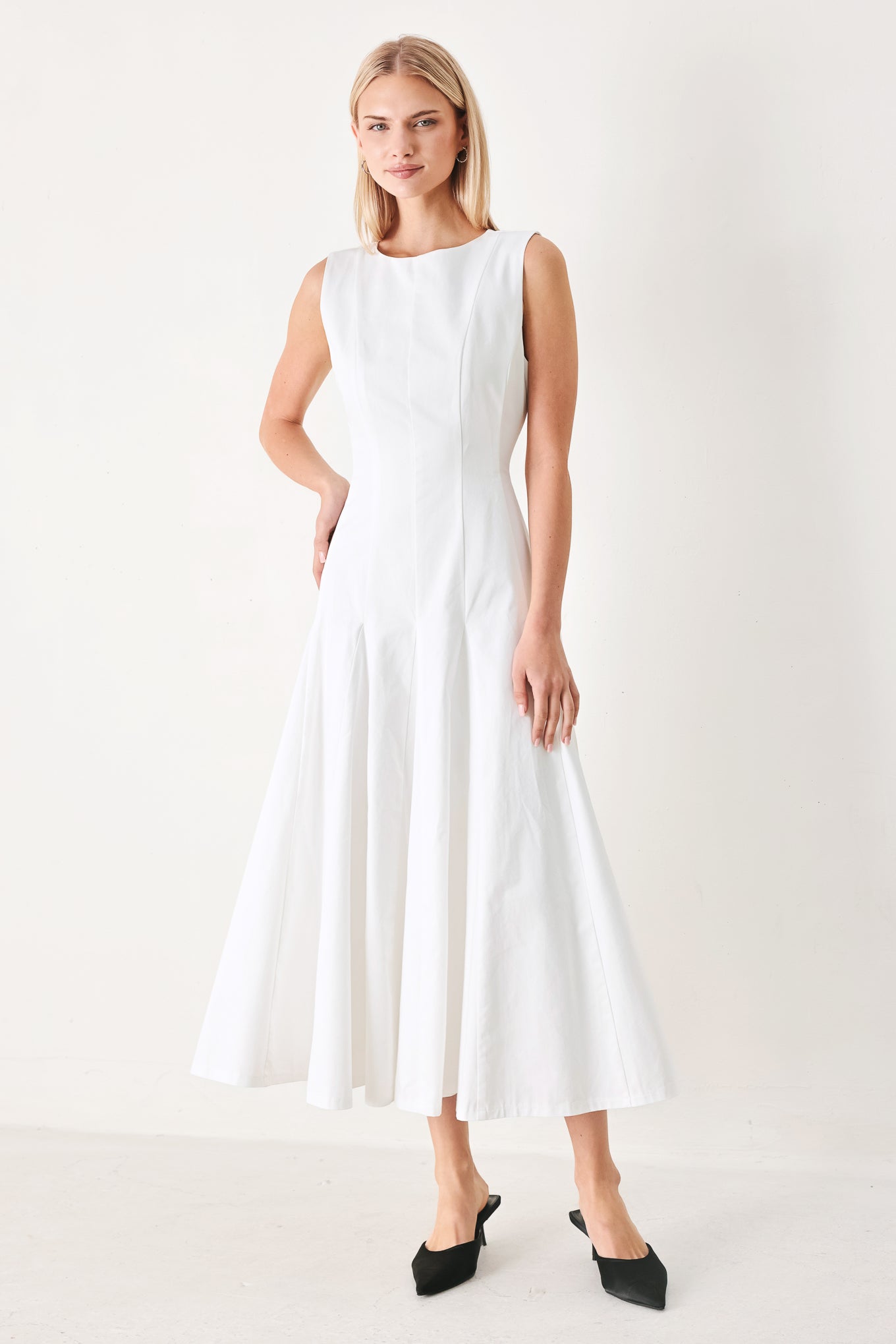 Woman wearing a white sleeveless midi dress featuring round neckline, sleeveless, full circle skirt and back zipper closure | FREEMARKET