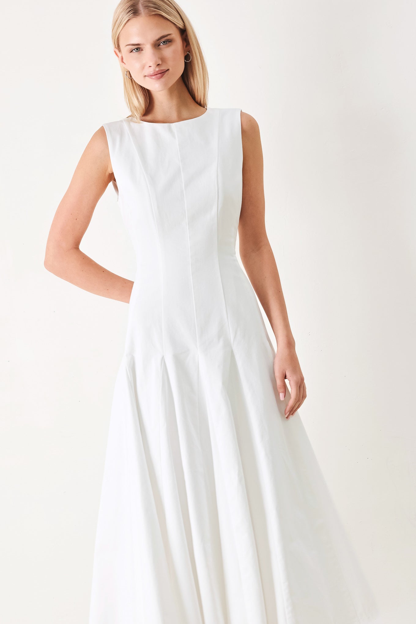 Woman wearing a white sleeveless midi dress featuring round neckline, sleeveless, full circle skirt and back zipper closure | FREEMARKET