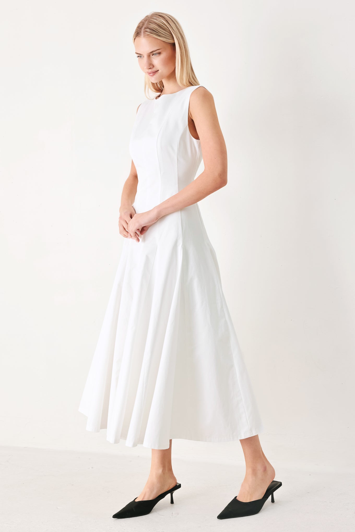 Woman wearing a white sleeveless midi dress featuring round neckline, sleeveless, full circle skirt and back zipper closure | FREEMARKET
