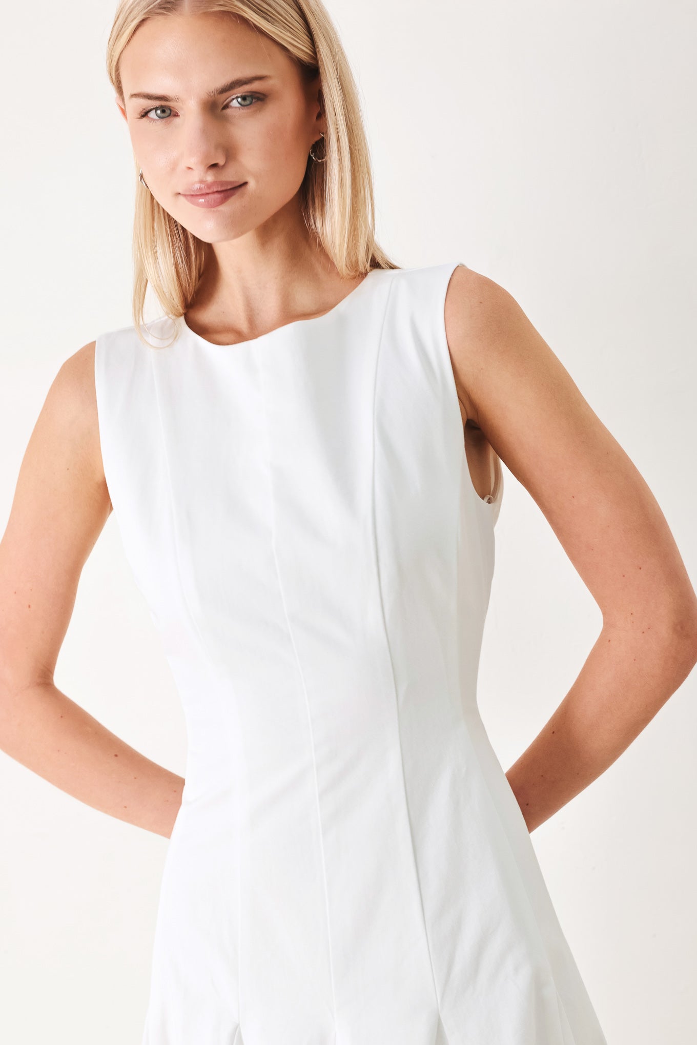 Woman wearing a white sleeveless midi dress featuring round neckline, sleeveless, full circle skirt and back zipper closure | FREEMARKET