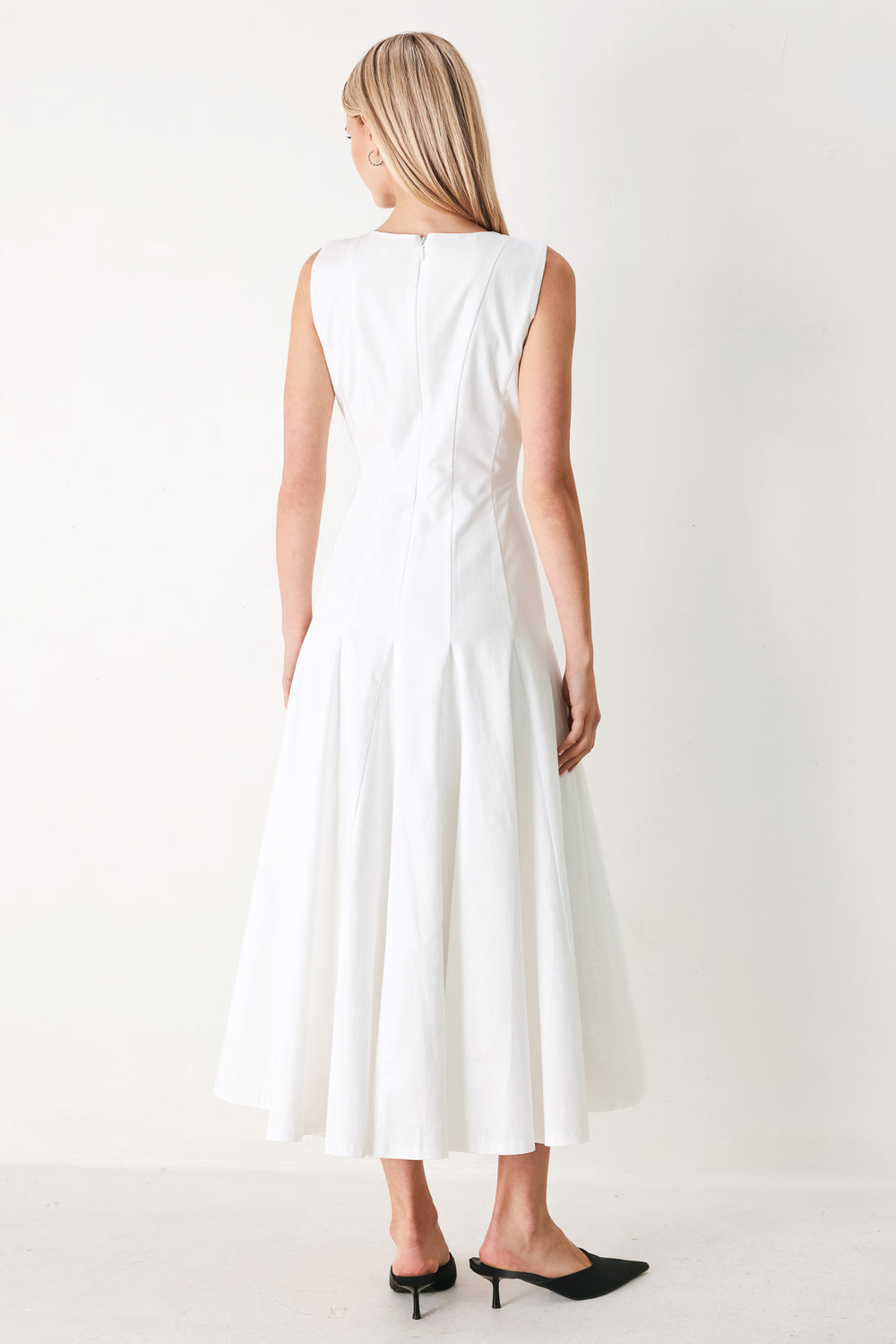 Woman wearing a white sleeveless midi dress featuring round neckline, sleeveless, full circle skirt and back zipper closure | FREEMARKET
