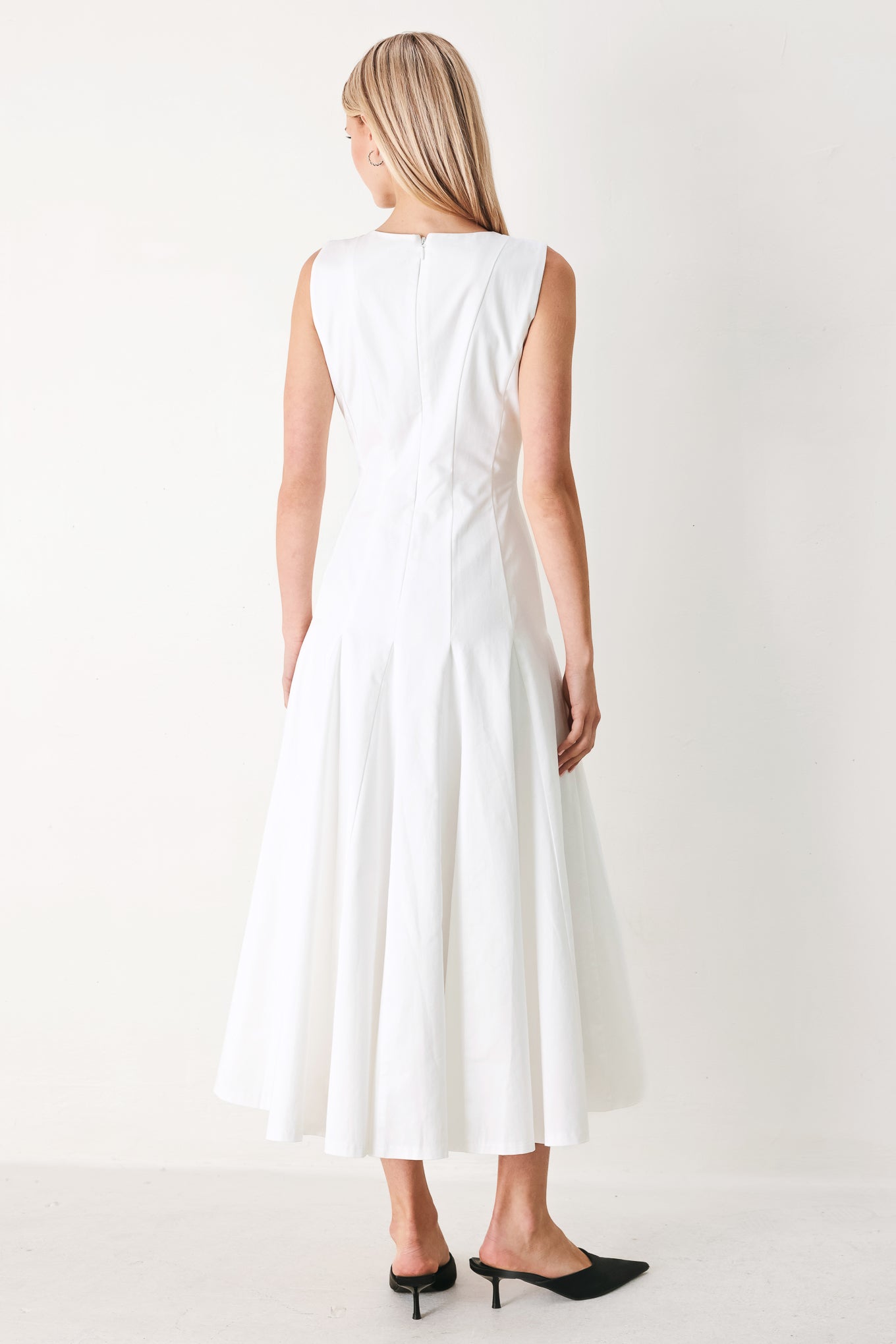 Woman wearing a white sleeveless midi dress featuring round neckline, sleeveless, full circle skirt and back zipper closure | FREEMARKET