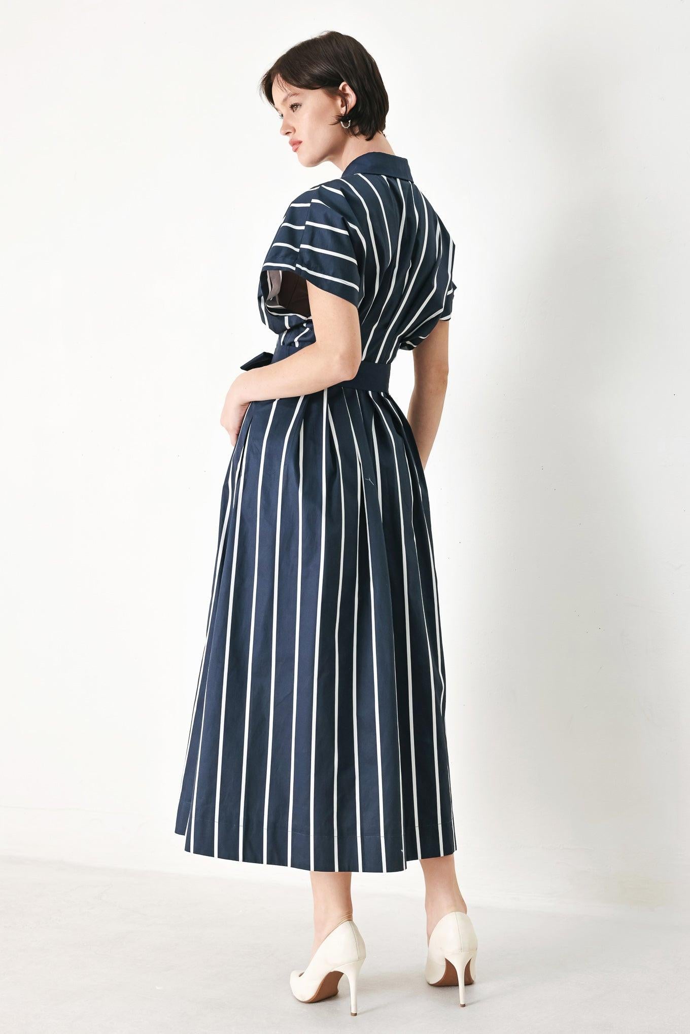 A striped woven midi dress featuring collar, button down, corset waist, solid self sash tie and full skirt