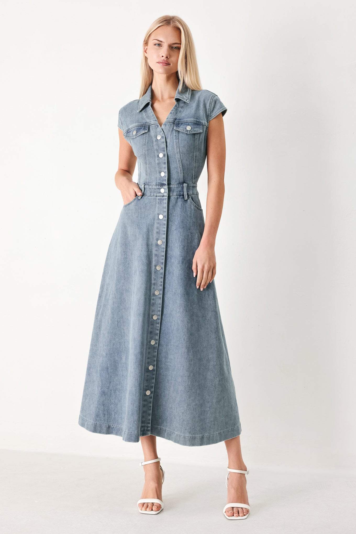 Woman wearing acid washed denim midi dress featuring collar with V neck, cap sleeve, front button down, pockets and circle skirt | FREEMARKET