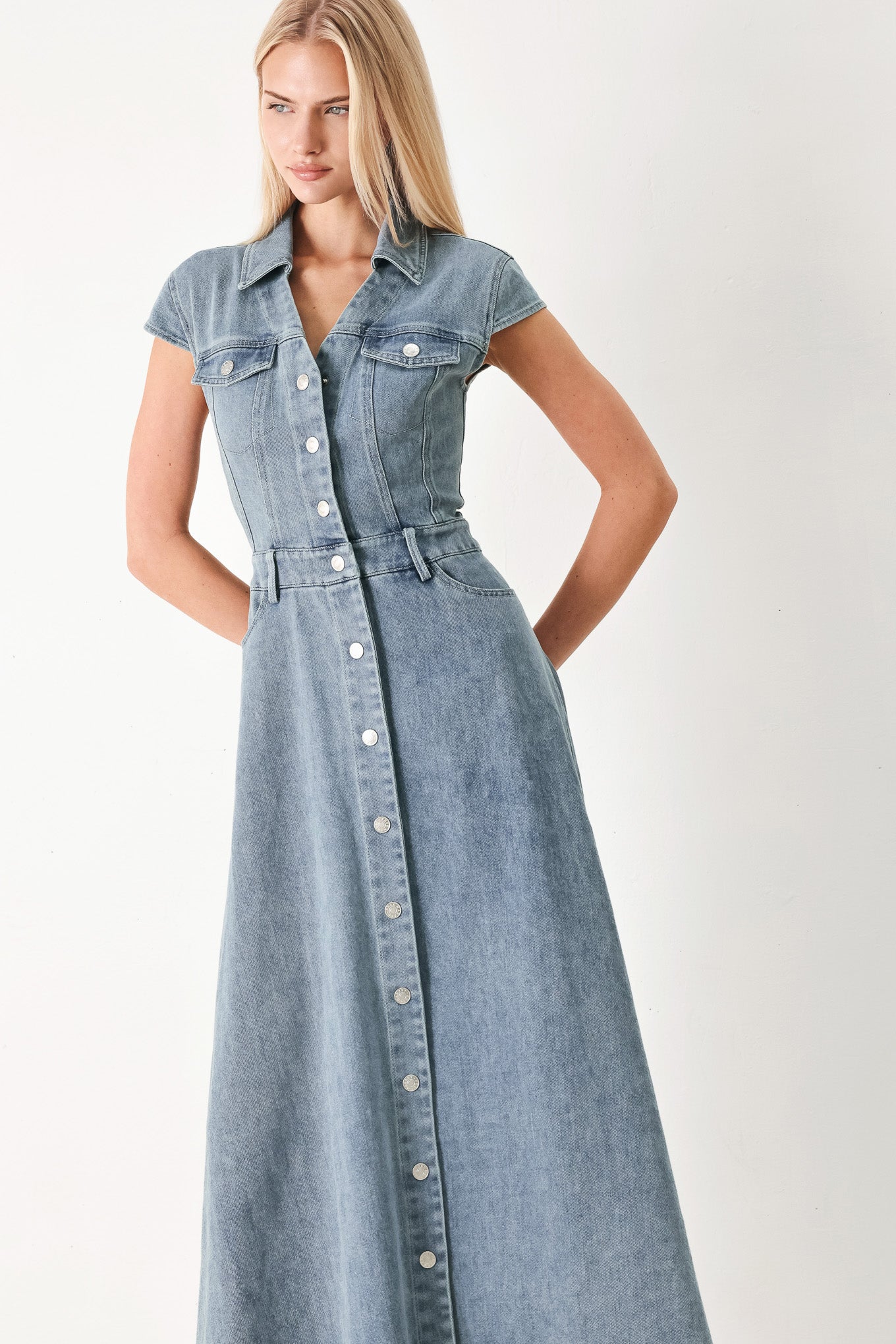 Woman wearing acid washed denim midi dress featuring collar with V neck, cap sleeve, front button down, pockets and circle skirt | FREEMARKET