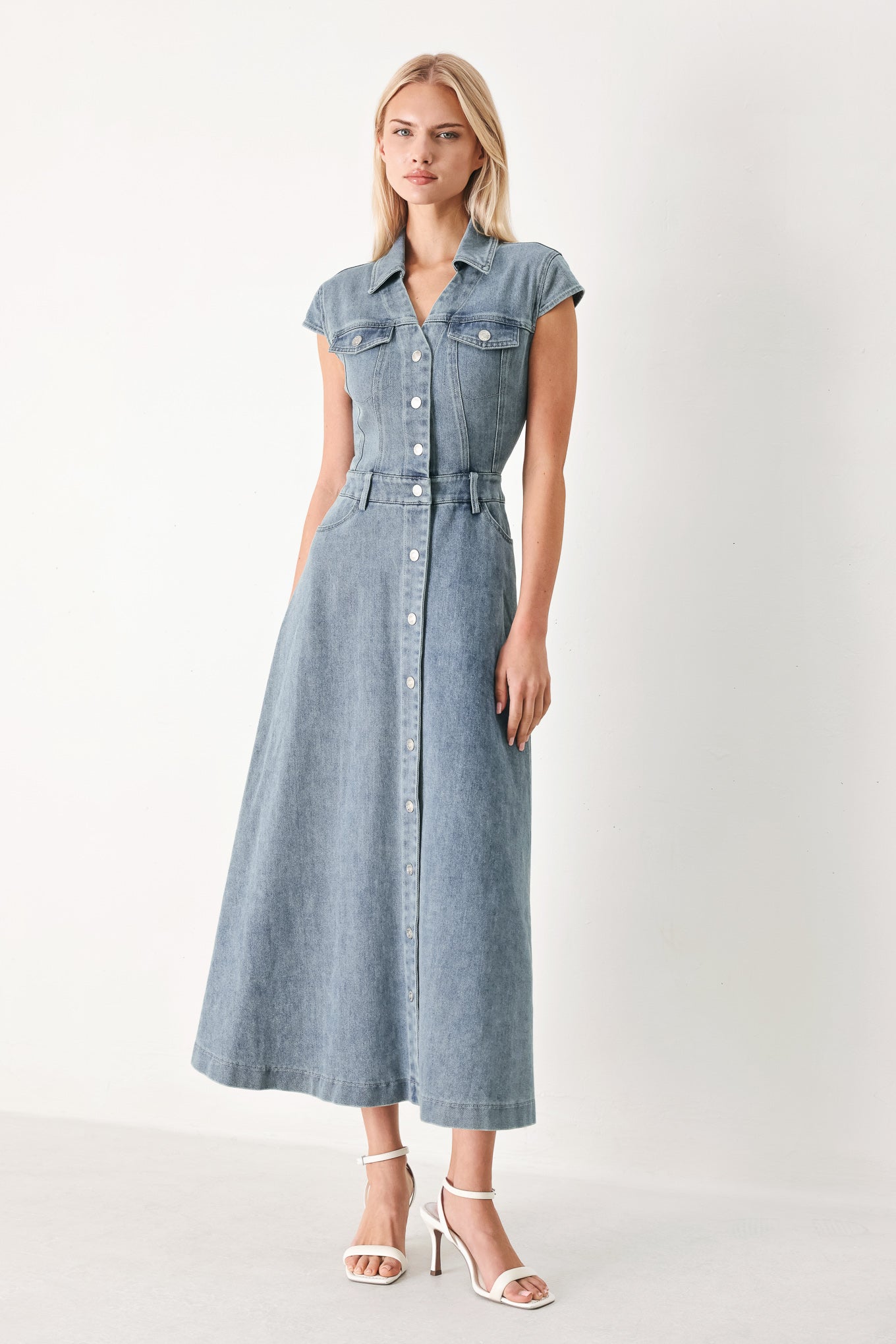 Woman wearing acid washed denim midi dress featuring collar with V neck, cap sleeve, front button down, pockets and circle skirt | FREEMARKET