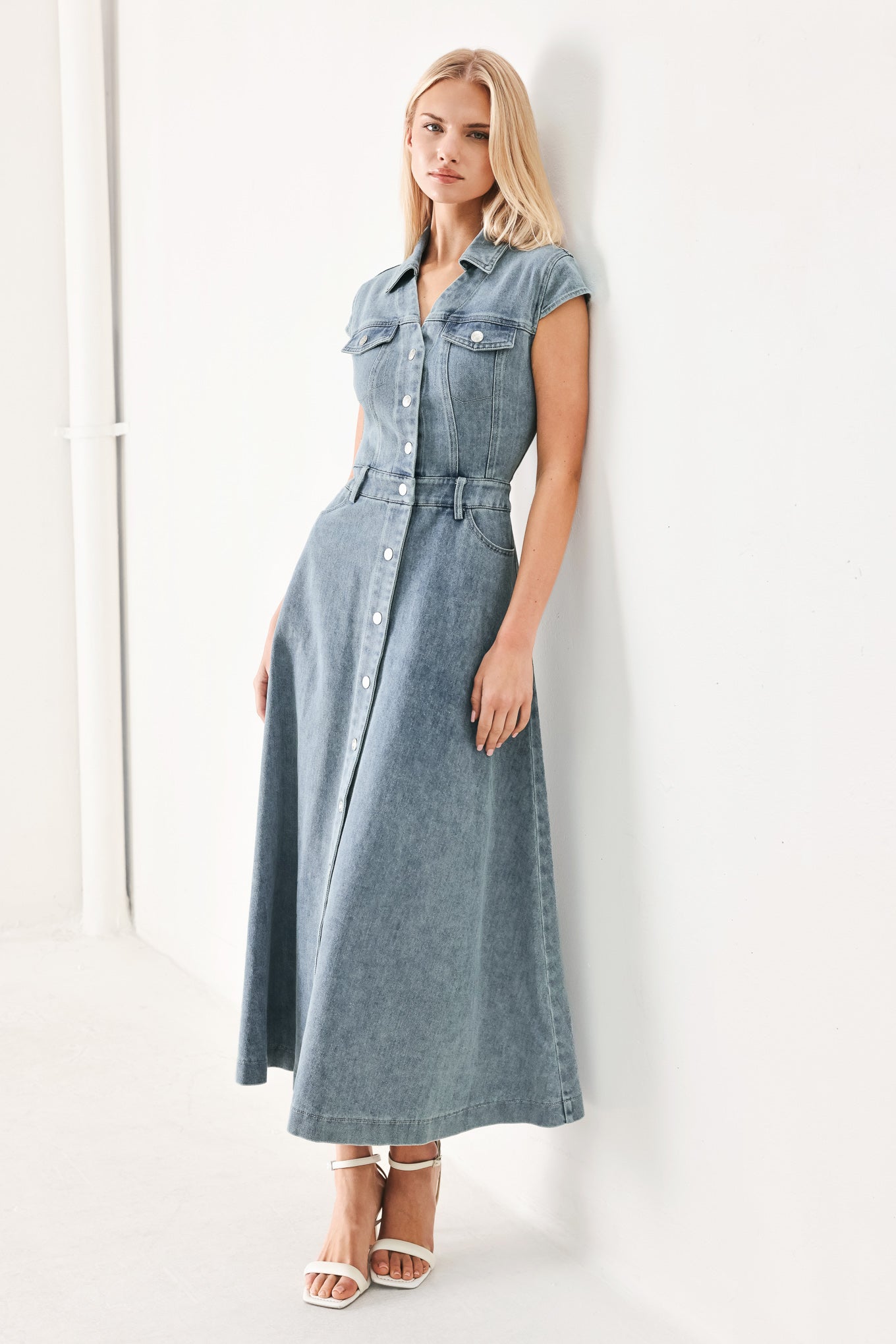Woman wearing acid washed denim midi dress featuring collar with V neck, cap sleeve, front button down, pockets and circle skirt | FREEMARKET