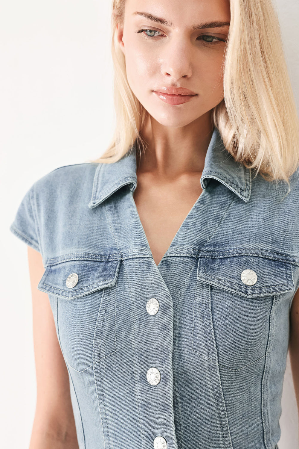 Woman wearing acid washed denim midi dress featuring collar with V neck, cap sleeve, front button down, pockets and circle skirt | FREEMARKET