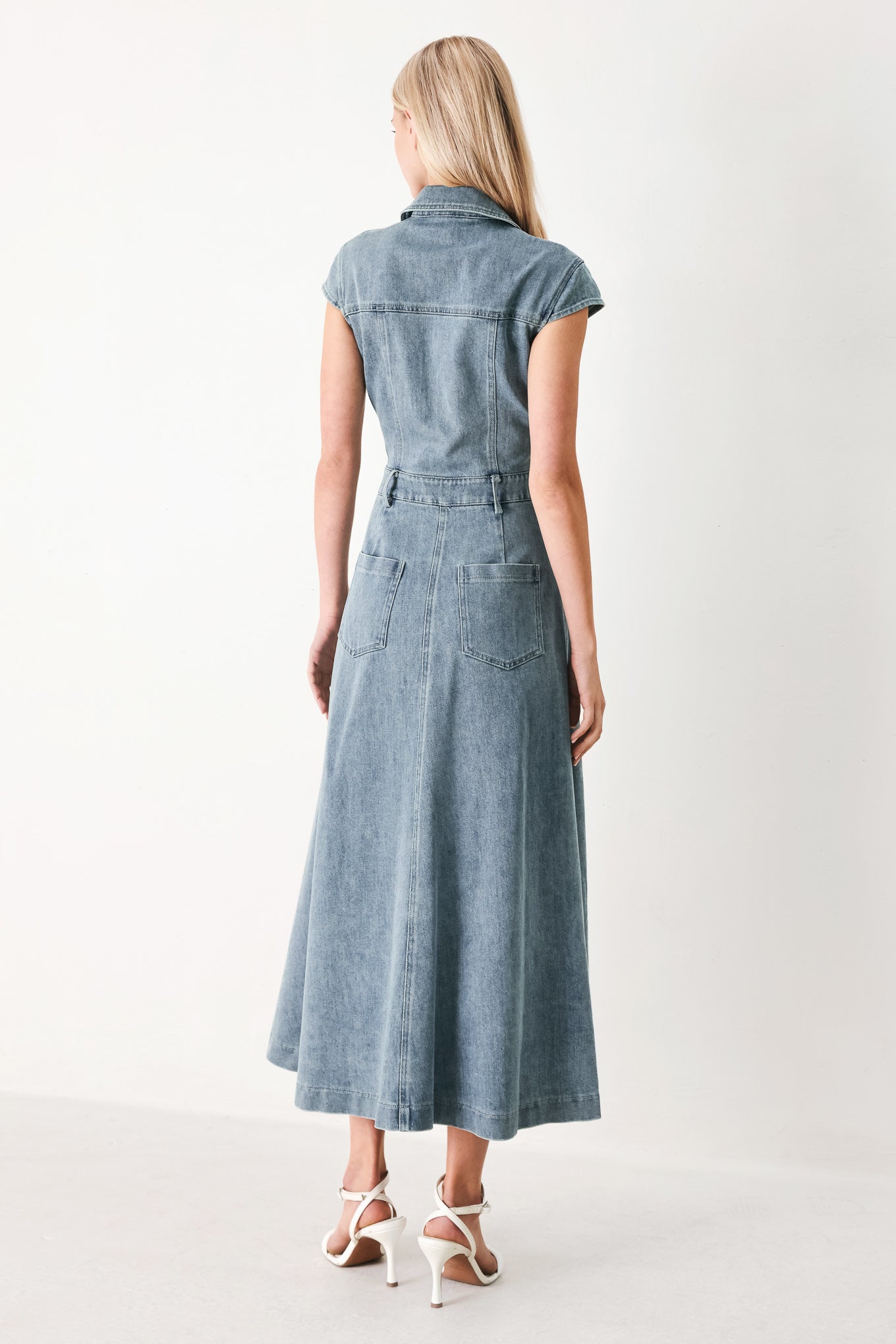 Woman wearing acid washed denim midi dress featuring collar with V neck, cap sleeve, front button down, pockets and circle skirt | FREEMARKET
