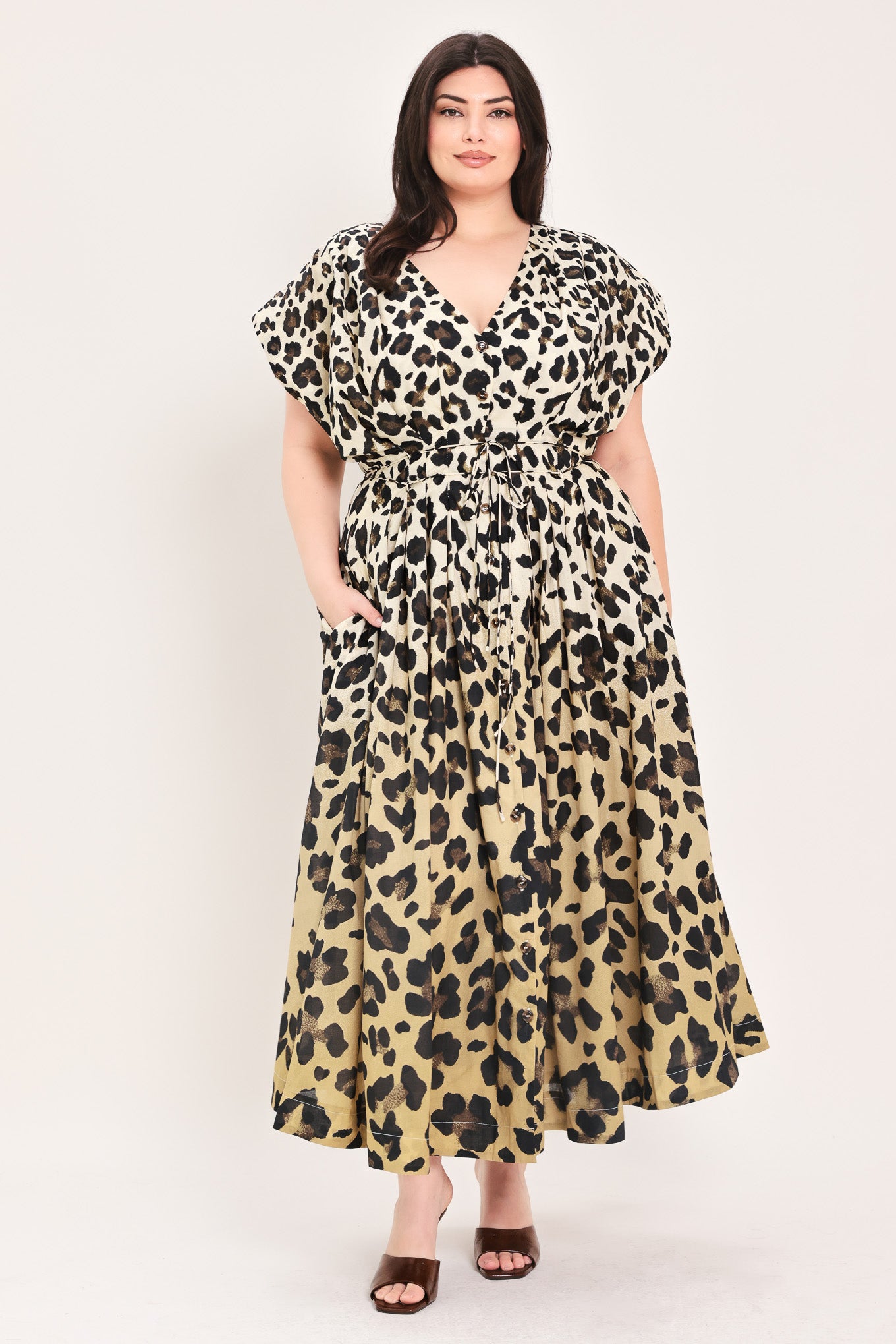 Woman wearing a leopard print woven midi dress featuring V neckline, drop shoulder, front button down, corset waist with pleats, double tie, side pockets and full skirt | FREEMARKET
