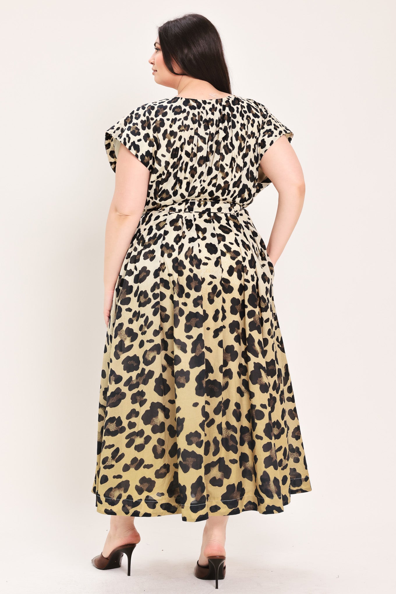 Woman wearing a leopard print woven midi dress featuring V neckline, drop shoulder, front button down, corset waist with pleats, double tie, side pockets and full skirt | FREEMARKET