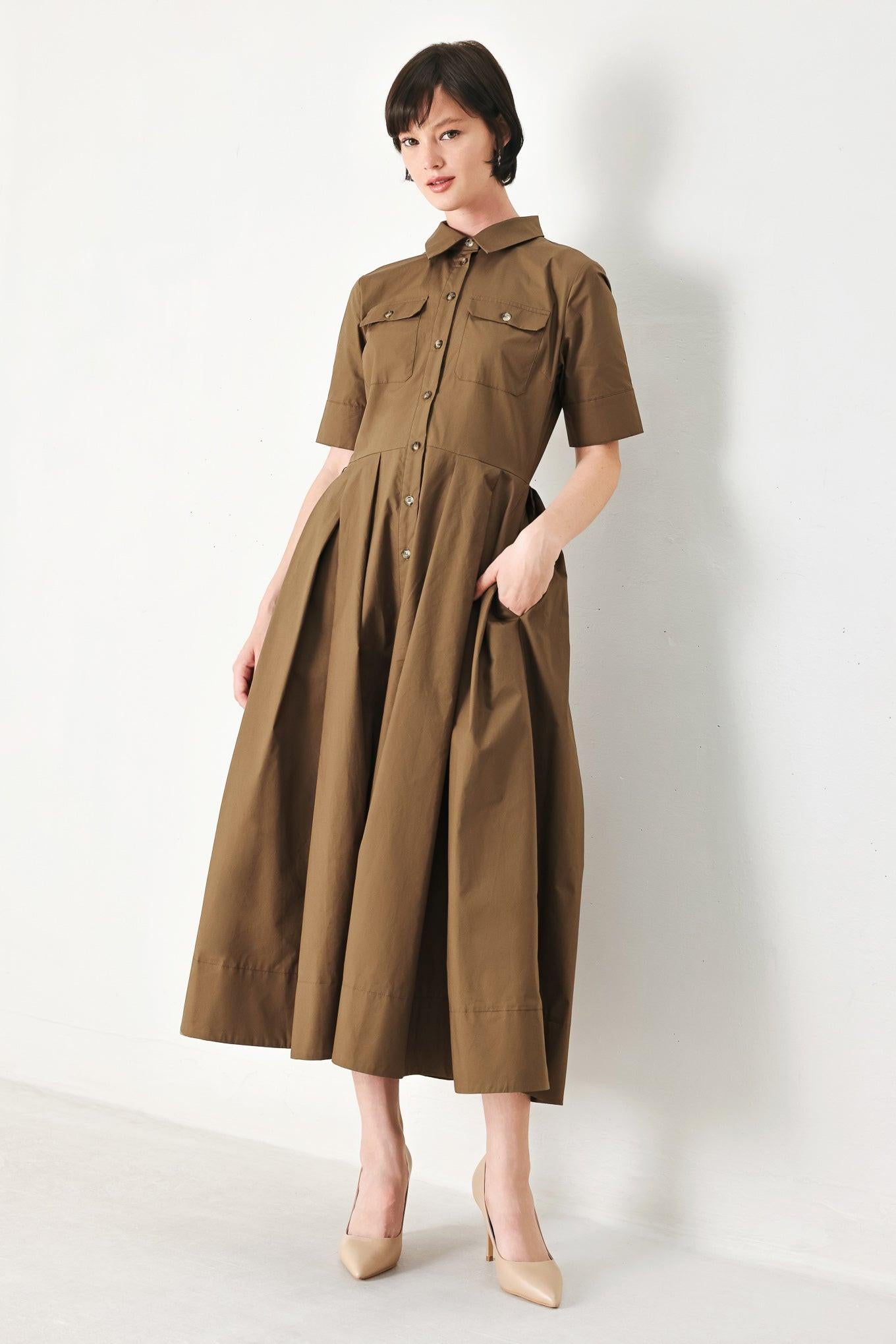 A solid brown woven midi shirt dress with short sleeve, pockets, self tie and front closure