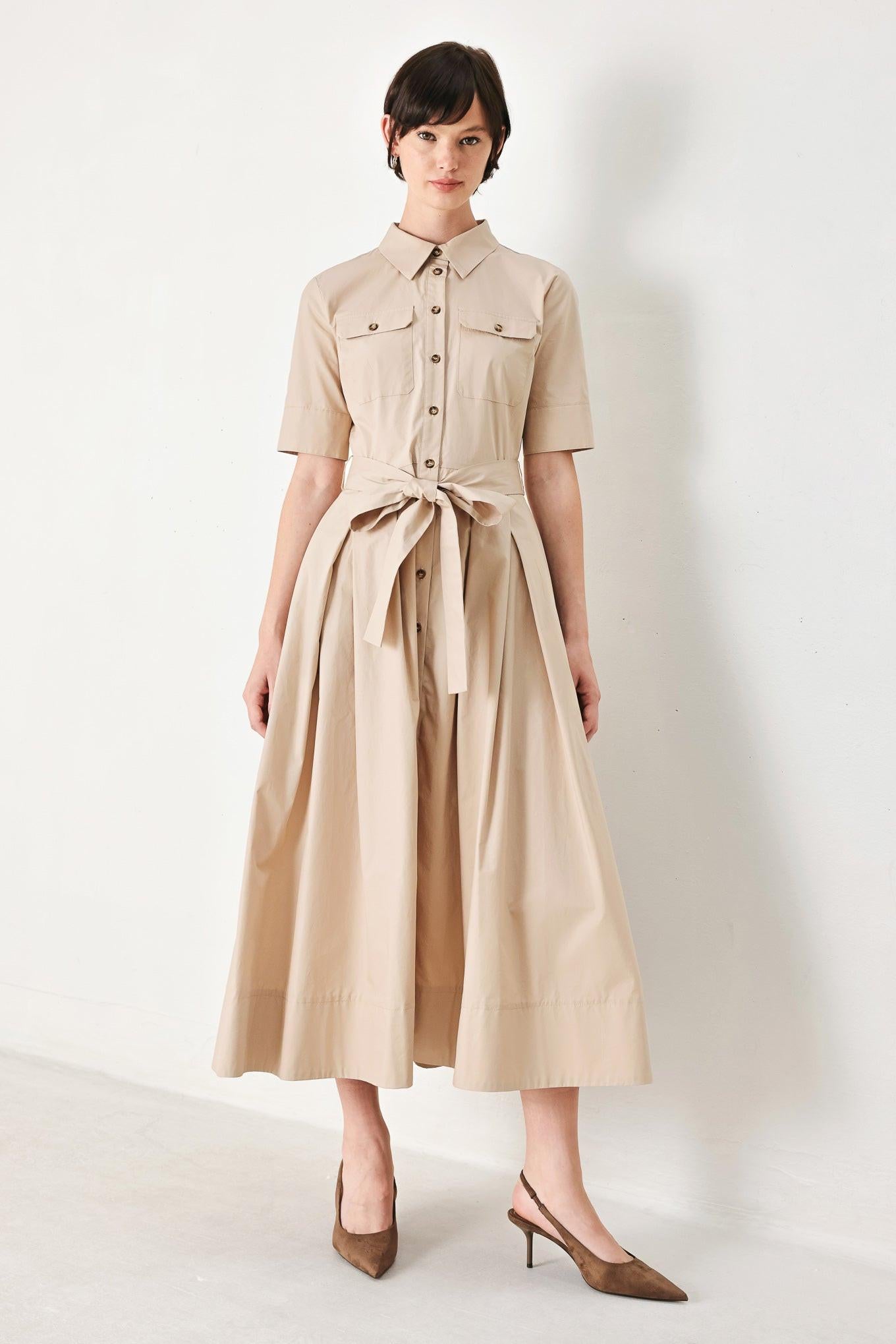 A solid neutral woven midi shirt dress with short sleeve, pockets, self tie and front closure