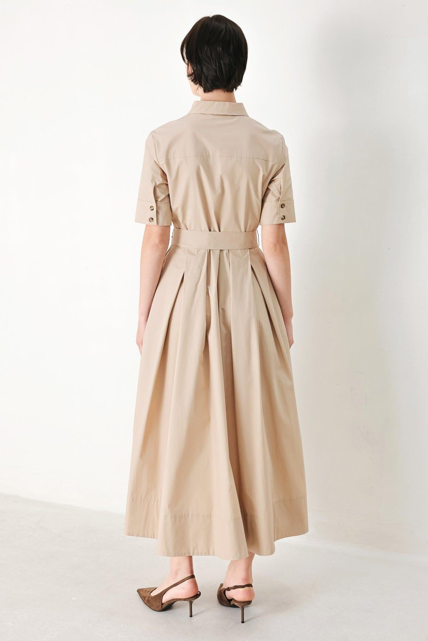 A solid neutral woven midi shirt dress with short sleeve, pockets, self tie and front closure