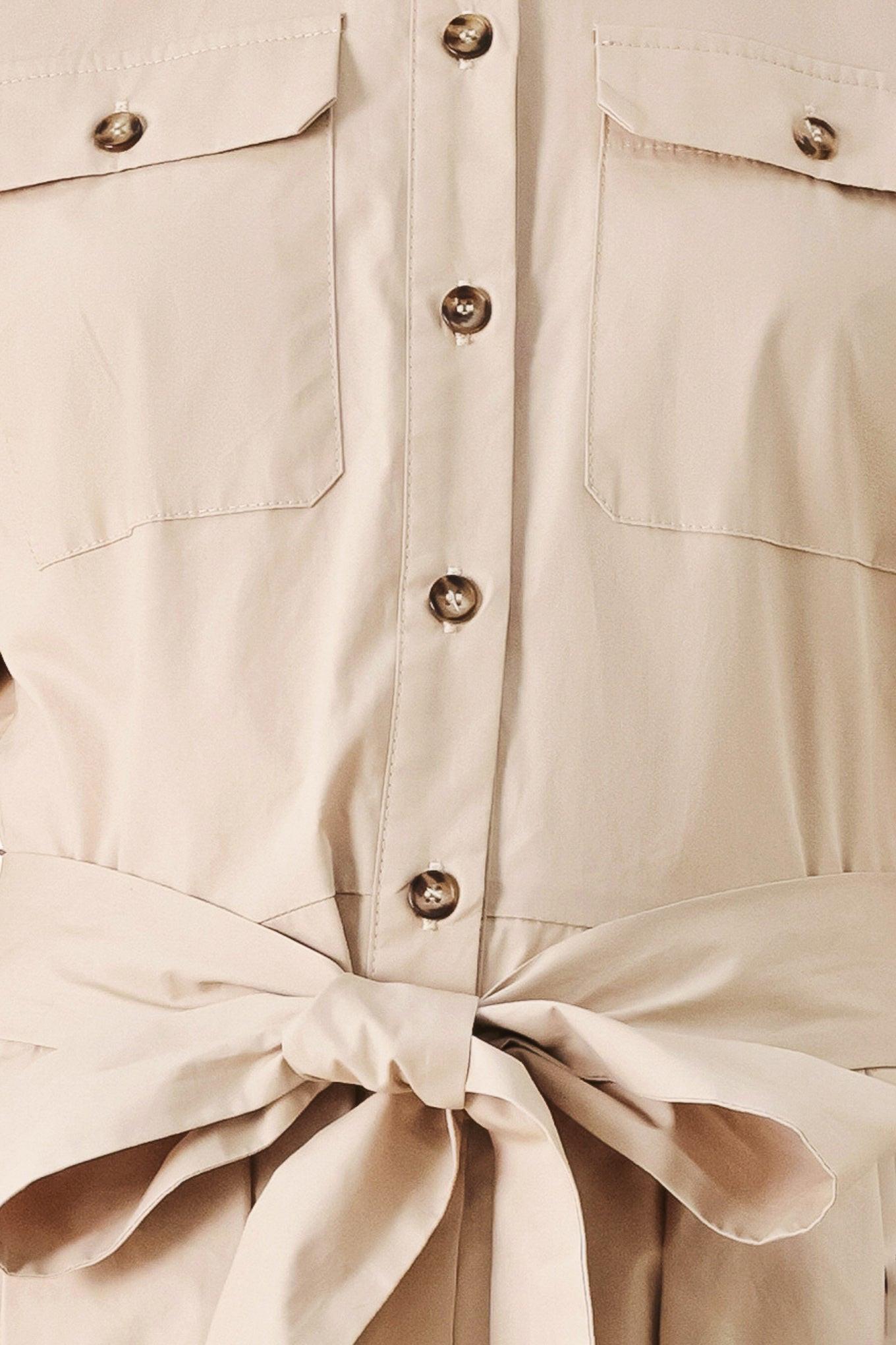A solid neutral woven midi shirt dress with short sleeve, pockets, self tie and front closure