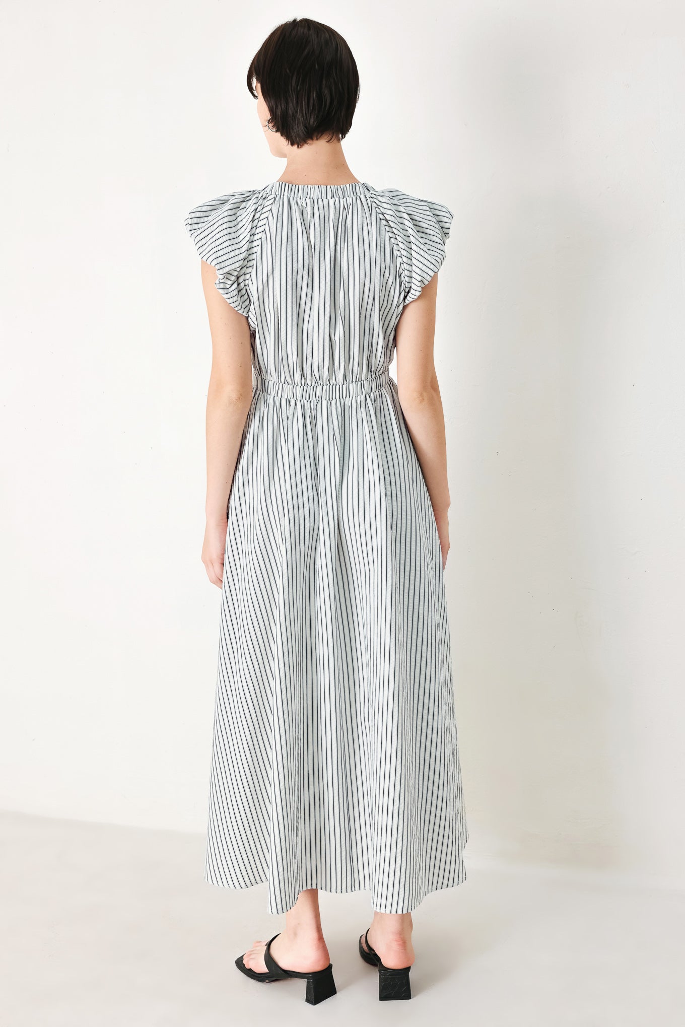 A striped woven midi dress featuring V neckline, short balloon sleeves, front tie, elastic at empire and full skirt