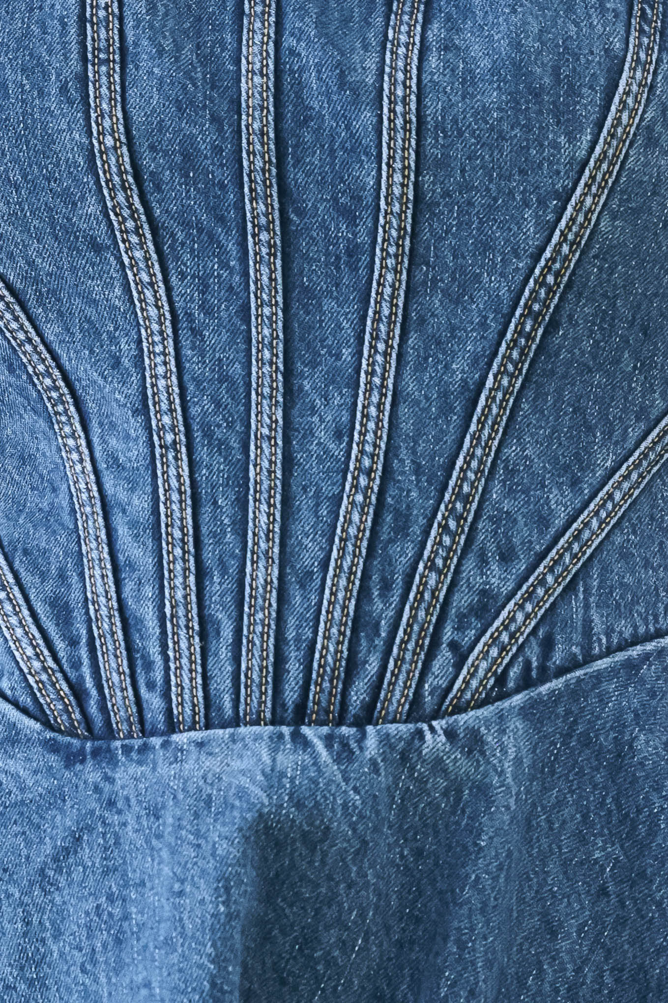 A washed denim mini dress featuring halter neckline with back button closure, full circle skirt bare back with zipper closure