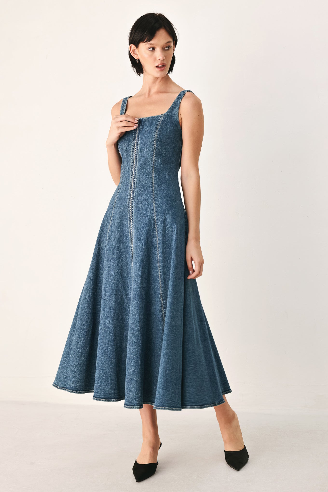 A woman modeling a sleeveless blue denim midi dress with a front zipper, square neckline, and flared skirt | FREEMARKET