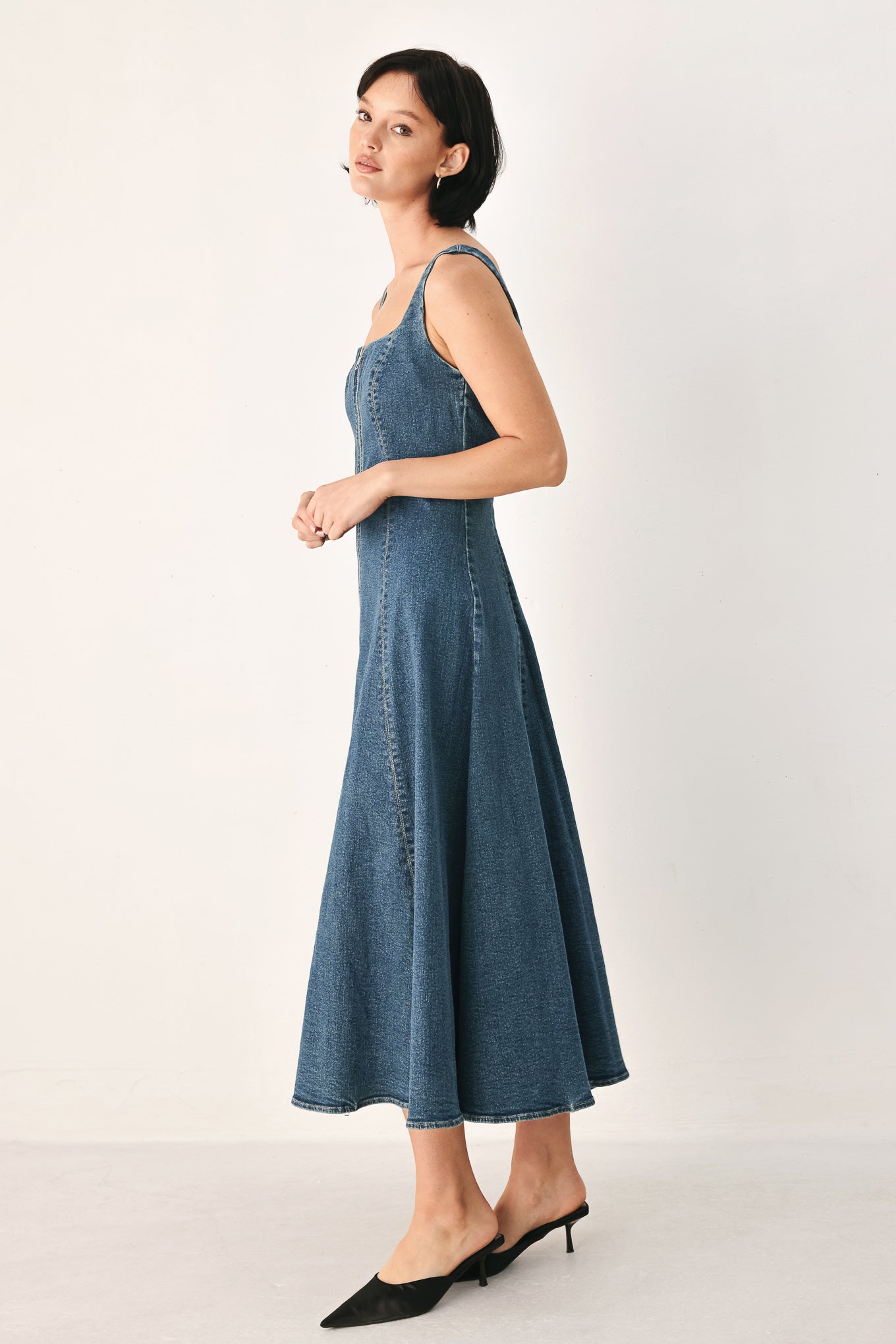 A woman modeling a sleeveless blue denim midi dress with a front zipper, square neckline, and flared skirt | FREEMARKET