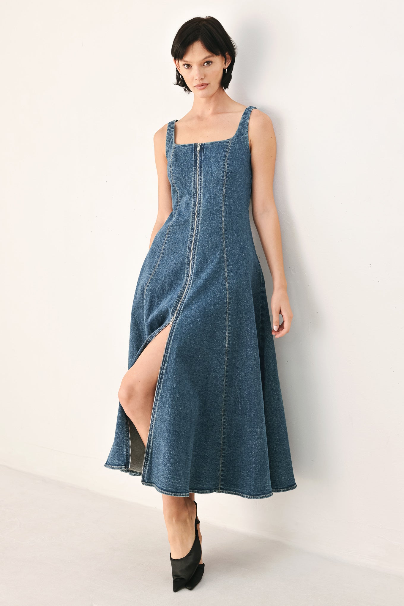 A woman modeling a sleeveless blue denim midi dress with a front zipper, square neckline, and flared skirt | FREEMARKET