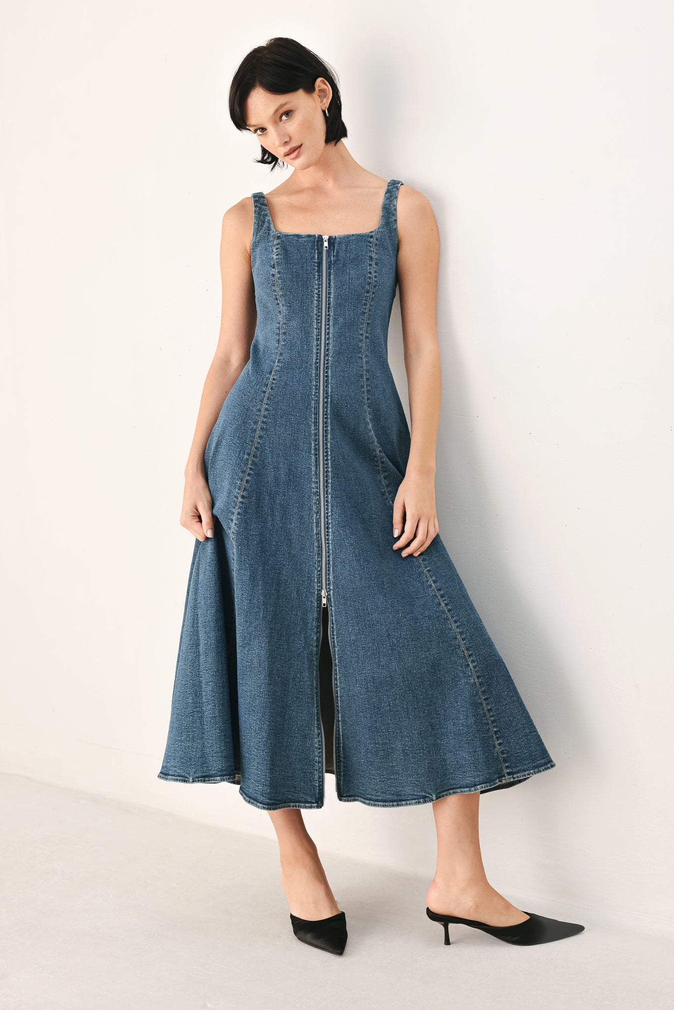 A woman modeling a sleeveless blue denim midi dress with a front zipper, square neckline, and flared skirt | FREEMARKET