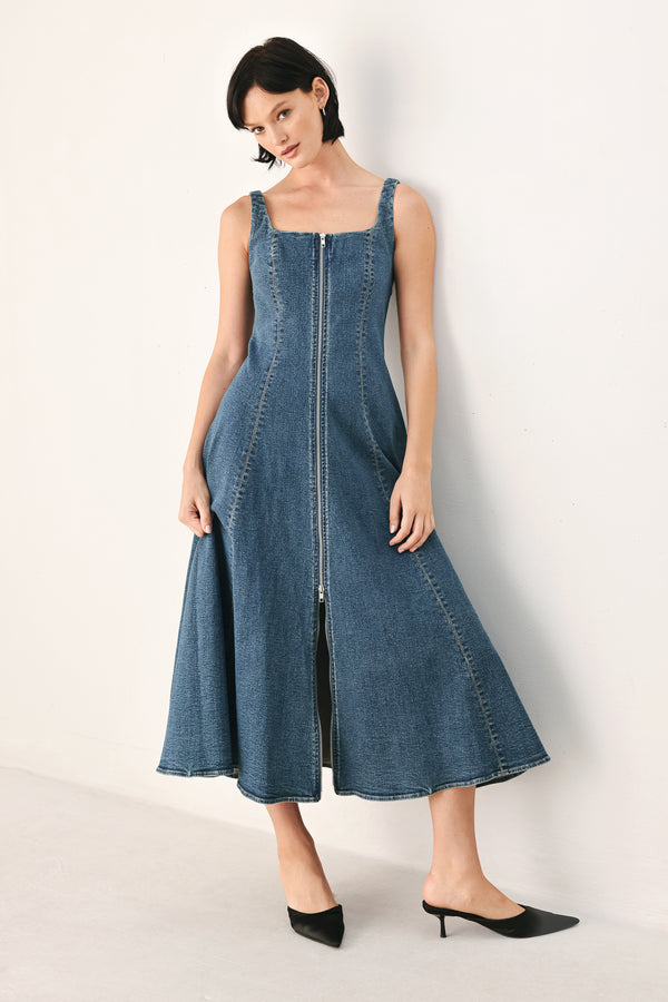 A woman modeling a sleeveless blue denim midi dress with a front zipper, square neckline, and flared skirt | FREEMARKET
