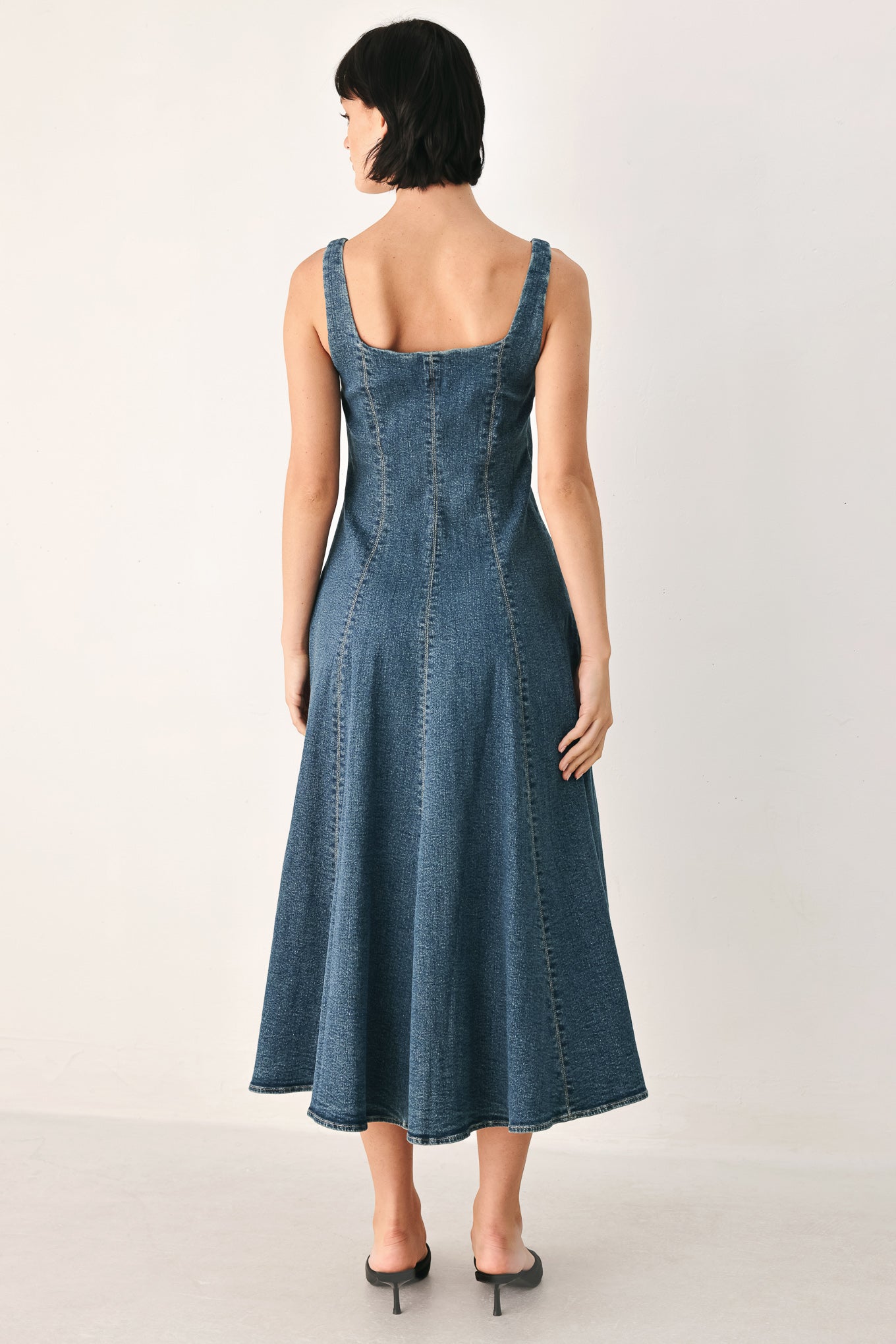 A woman modeling a sleeveless blue denim midi dress with a front zipper, square neckline, and flared skirt | FREEMARKET